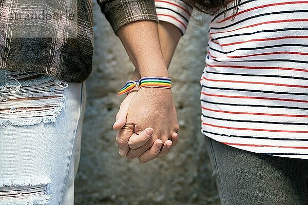 Nahaufnahme eines glücklichen lesbischen Paares  das sich an den Händen hält und ein Armband mit Regenbogenflagge trägt  LGBT Liebeskonzept. Hohe Qualität FullHD Filmmaterial