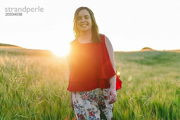 Nettes Mädchen in rotem Kleid  lachend mit Freude im Freien in der Frühlingszeit Sonnenuntergang