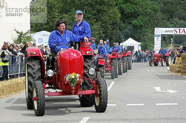 Porsche Diesel Traktoren  Fröhliche Fahrer lenken rote Traktoren bei einer Parade vor Publikum  SOLITUDE REVIVAL 2011  Stuttgart  Baden-Württemberg  Deutschland  Europa