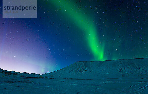 Aurora Borealis über schneebedeckten Bergen