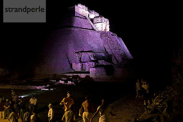 Touristen spazieren nach einer theatralischen Laserlichtshow auf der Halbinsel Yucatan in Mexiko zwischen den Maya-Ruinen von Uxmal