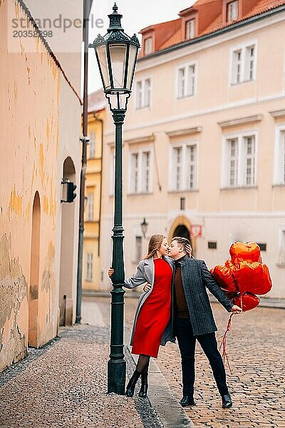 Junges Paar geht mit Luftballons im Herzen durch Prag