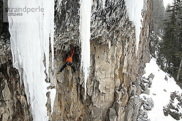 Ein männlicher Eiskletterer klettert eine extrem schwierige M10-Mixed-Linie in der Höhle  Hyalite Canyon  Montana.