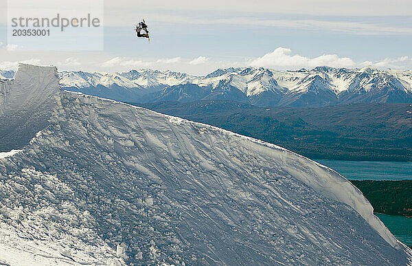 Ein Snowboarder macht einen Backcountry-Sprung und macht einen klassischen Snowboard-Trick im Cerro Catedral  Argentinien