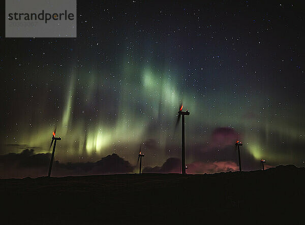 Windturbinen für erneuerbare Energien und Nordlichter bei Nacht