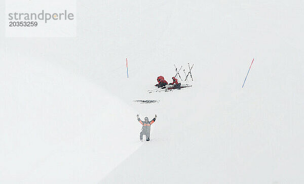 Ein Pistenwächter führt den Piloten des Rettungshubschraubers durch Hinweise im wirbelnden Schnee.