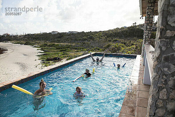 Große  glückliche Familie im Infinity-Pool im Karibikurlaub