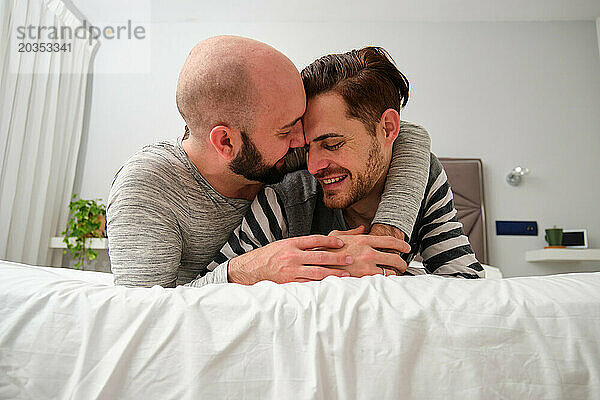 Homosexuelles glückliches Paar  das sich verliebt im Bett umarmt.