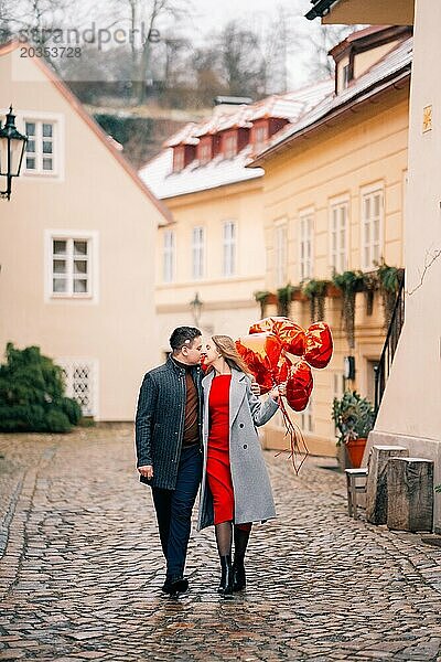 Junges Paar geht mit Luftballons im Herzen durch Prag