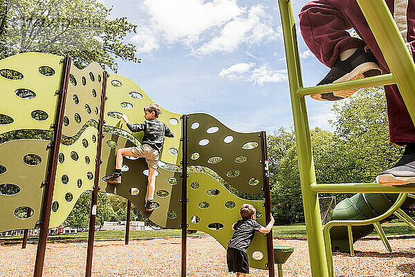 Spielplatz mit Füßen im Vordergrund und zwei Kindern dahinter