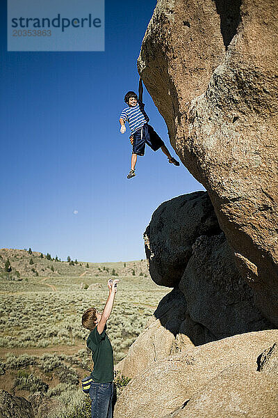 Ein junger Kletterer hängt an der Spitze eines Felsbrockens bei Hartman Rocks außerhalb von Gunnison  Colorado.