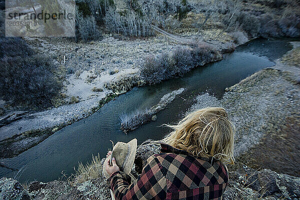 Erhöhte Ansicht eines Mannes  der auf einer Klippe über dem Fluss sitzt  New Mexico  USA