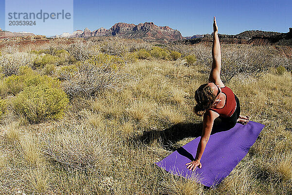 Eine Frau macht Yoga draußen in Springdale  Utah.