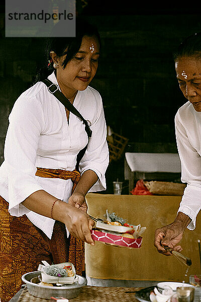 Traditionelle balinesische Zeremonie  bei der Frauen den Geistern Opfergaben darbringen.