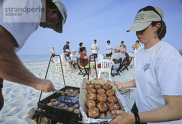 Zwei Personen bereiten Krabbenkuchen am Strand von Tanger Island  Virginia  zu.