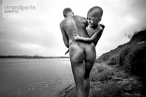 Mutter trägt Sohn auf dem Wasser  während Sohn lacht  Red River  Vietnam.