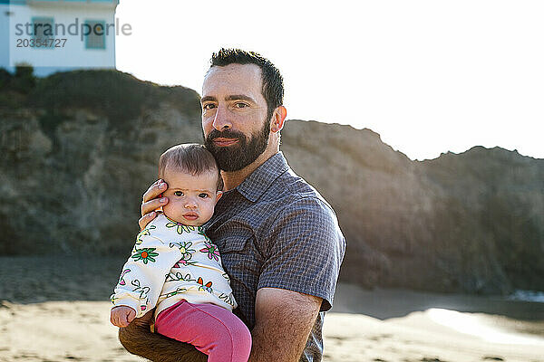 Stolzer Vater und kleine Tochter fühlen sich am Strand ruhig
