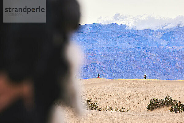 Fernsicht auf Menschen  die auf Sanddünen im Death Valley laufen