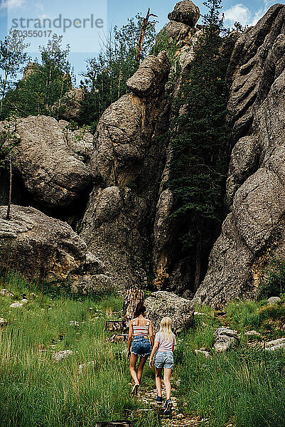 Große Naturszene mit zwei Teenager-Mädchen  die einen Hügel hinaufwandern.