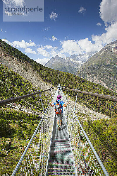 Ältere Wanderin auf der Charles-Kuonen-Hängebrücke in den Schweizer Alpen  Randa  Kanton Wallis  Schweiz