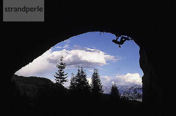 Mann in Silhouette klettert kopfüber unter einem Dach im Maple Canyon  Utah.