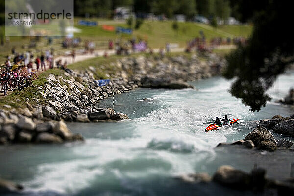 Kajakfahrer  die an einem Kajakwettbewerb auf dem Fluss in Bourg St. Maurice  Savoie  Frankreich  teilnehmen. (Selektiver Fokus)