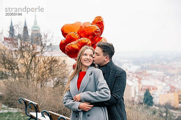 Junges Paar geht mit Luftballons im Herzen durch Prag