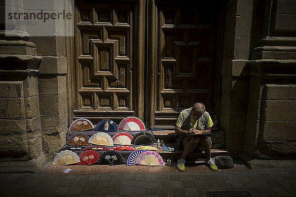 Ein Mann malt Handfächer in einer Straße in Malaga  Andalusien  Spanien.