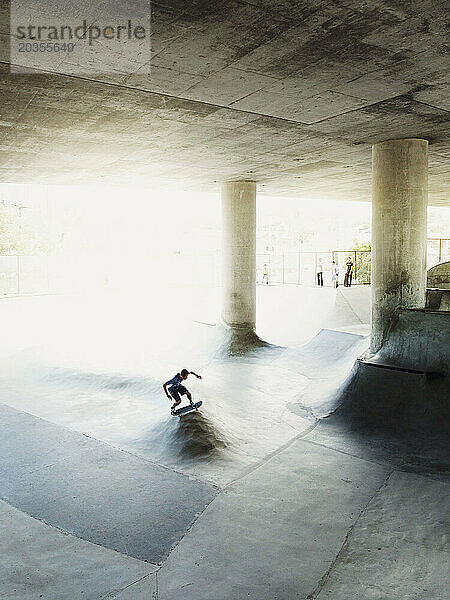 Ein Mann läuft im Skateboardpark von San Diego Schlittschuh. Nur wenige Leute beobachten ihn von einem Aussichtspunkt aus.