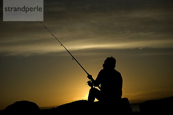 Ein Mann fischt bei Sonnenuntergang im Yachthafen von La Paz  der Hauptstadt des südlichen mexikanischen Bundesstaates Baja California