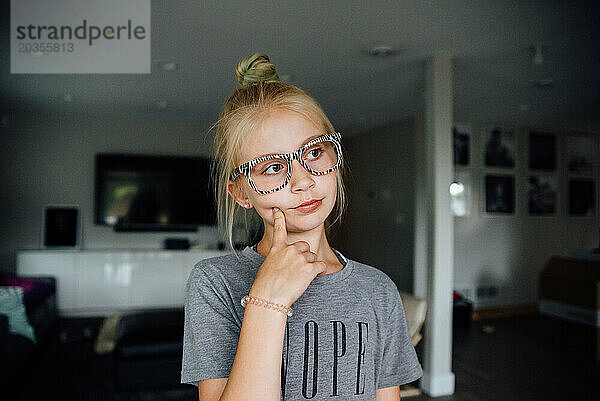 Porträt eines jugendlichen Mädchens mit Brille  das drinnen nachdenklich aussieht