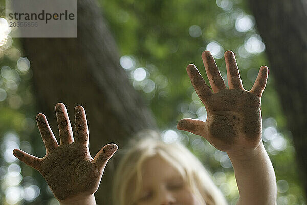 Junges rothaariges Mädchen  3-5 Jahre  posiert mit schmutzigen Händen draußen in Center Harbor  New Hampshire.