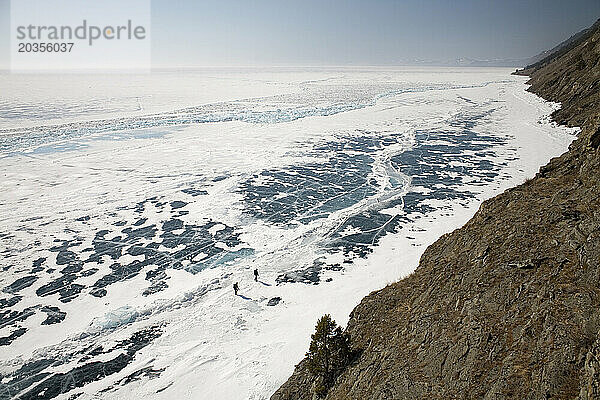 Zwei Menschen wandern im Winter auf dem zugefrorenen Baikalsee  Sibirien  Russland.