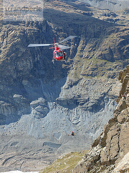 Ein Rettungshubschrauber evakuiert einen verletzten Bergsteiger aus einer steilen Felswand