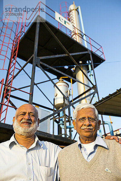 Zwei indische Männer posieren vor einer Metallplattform