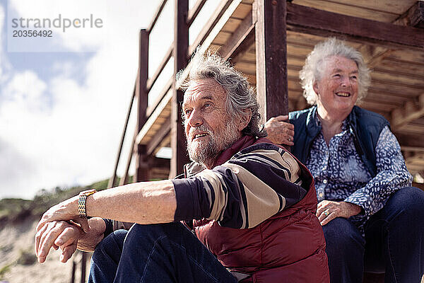 Glückliches älteres Rentnerehepaar lacht gemeinsam am Strand von Australien