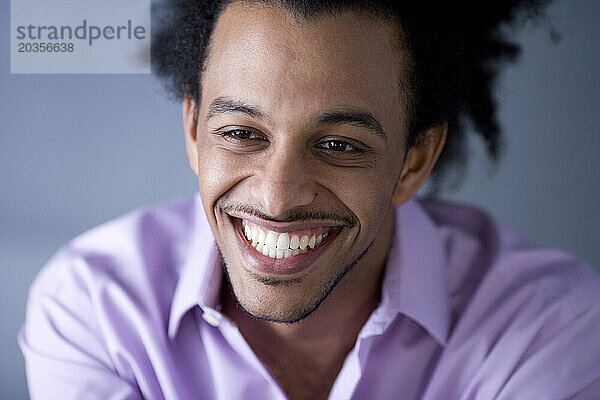 Afroamerikanischer Mann mit riesigem Afro-Lächeln.