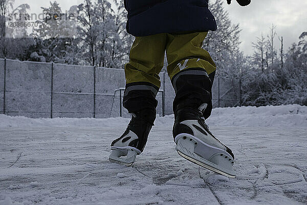 Kind beim Eislaufen draußen im Schnee in Schweden