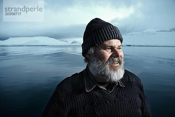 Ein Mann mit grauem Bart in einer Winterlandschaft