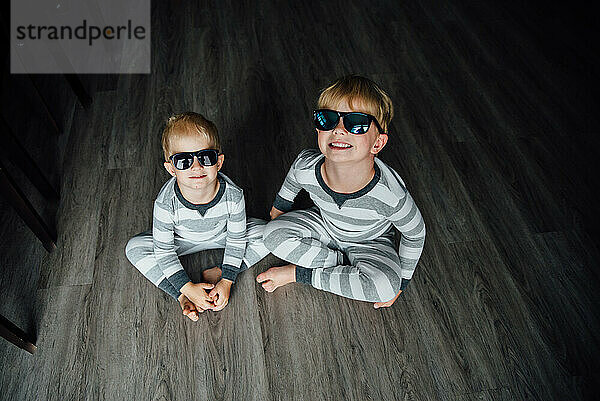 Draufsicht auf zwei lächelnde Brüder mit aufgesetzter Sonnenbrille