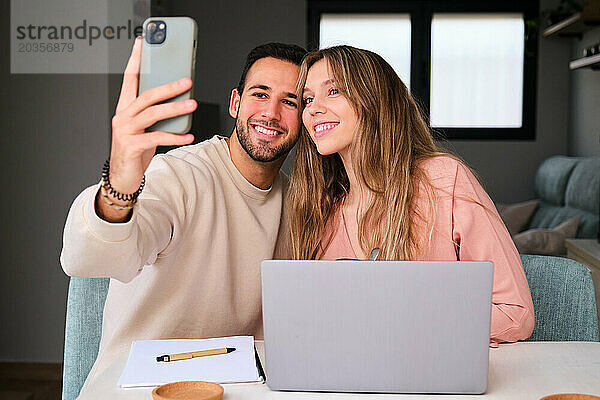 Spanisches glückliches Paar  das zu Hause gemeinsam ein Selfie macht.