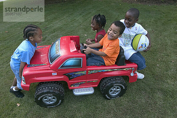 Kleine Kleinkinder spielen in ihrer Nachbarschaft in Atlanta  Georgia  mit einem Elektroauto.