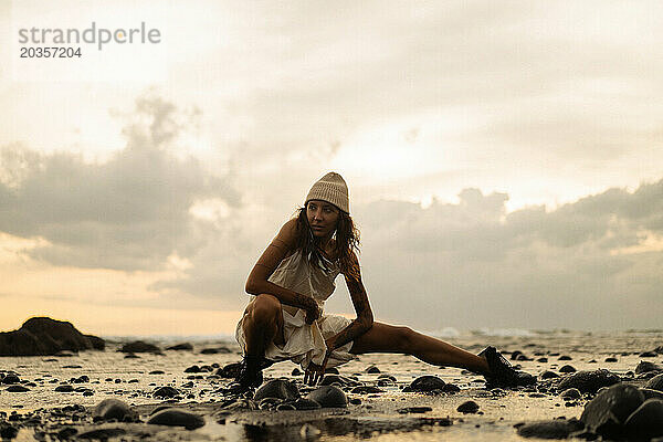Glückliche junge Frau am Strand bei Sonnenuntergang  Medewi