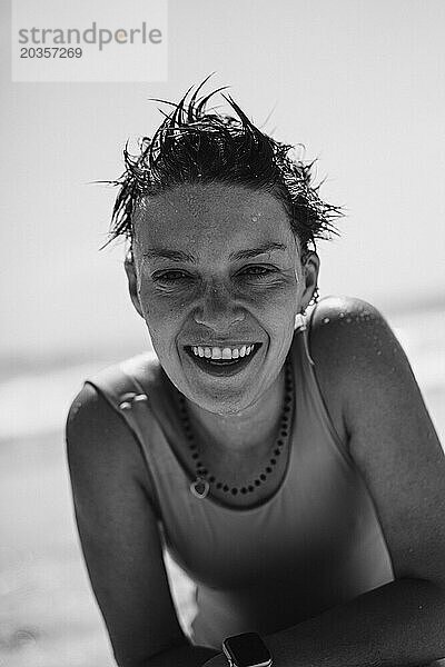 Glückliche  lachende Frau  Porträt  Sand im Gesicht. Schwarz-Weiß-Foto.