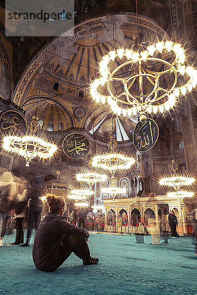 Ein Mann saß auf einem grünen Teppich in der Moschee Hagia Sophia