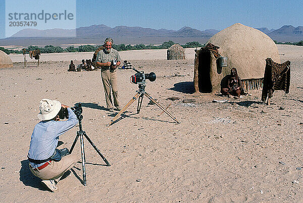Zwei Menschen filmen ein Dorf  Namibia.