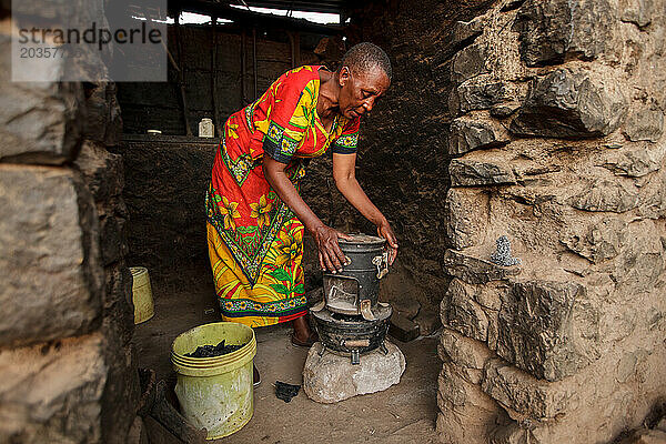 Tansanische Frau bereitet sich darauf vor  das Abendessen auf dem Herd zu kochen