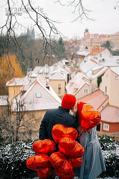 Junges Paar geht mit Luftballons im Herzen durch Prag