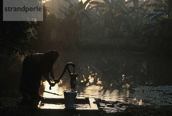 Im Dorf Dhulibati  Westbengalen  Indien  füllt Urmila Naskar in den frühen Morgenstunden Wasser aus einem Rohrbrunnen.