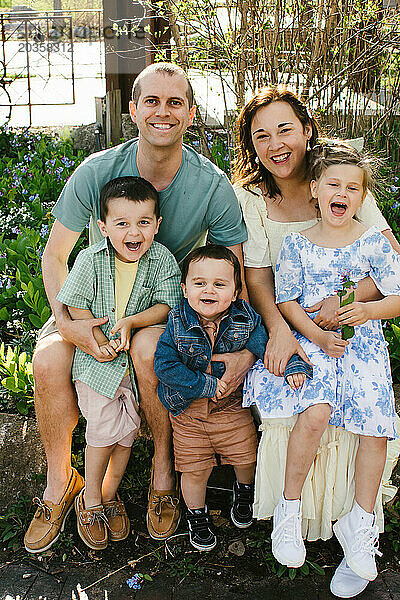 Familie mit mehreren Kindern lächelt und lacht im Frühling gemeinsam